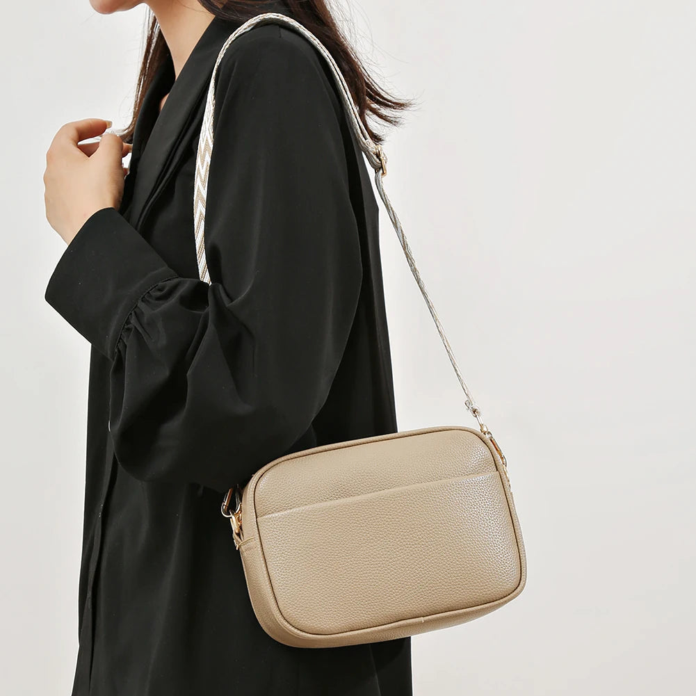 Chic woman holding an elegant designer crossbody purse in beige, perfect for everyday use