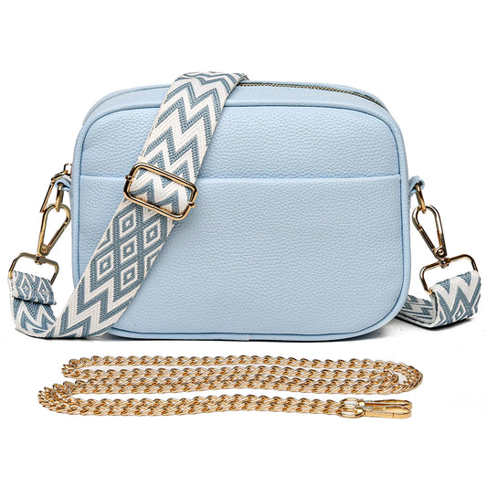 Elegant designer crossbody purse in light blue with a decorative strap and gold chain for stylish use