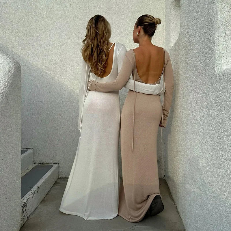 Two women wearing elegant off shoulder evening dress in white and beige against a modern backdrop