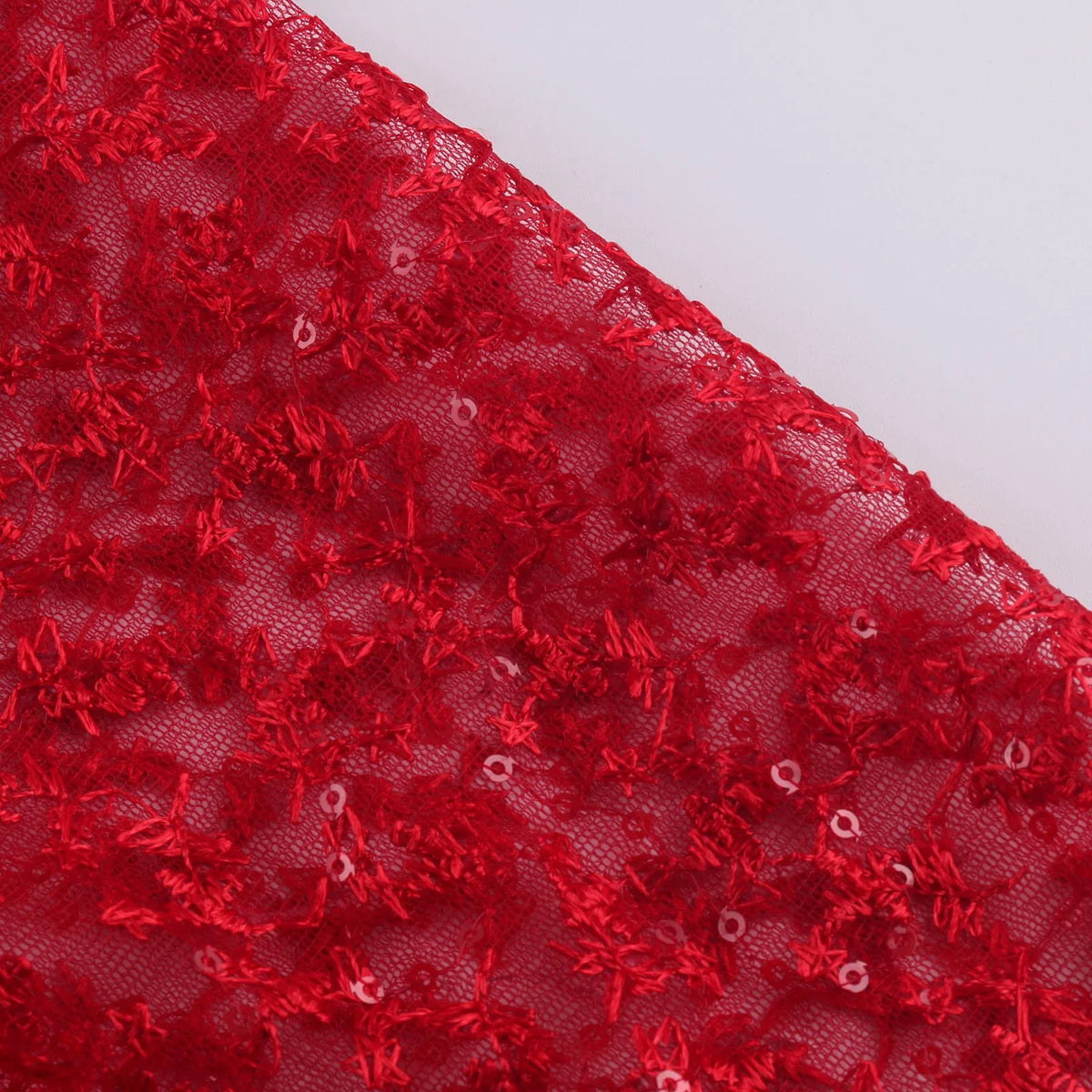 Close-up of elegant red fabric with intricate lace patterns for elegant prom and gala dresses