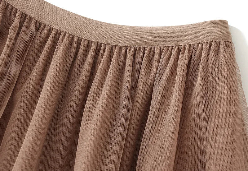 Close-up of the waistband and fabric of an elegant ruffle edge skirt for women in soft brown color