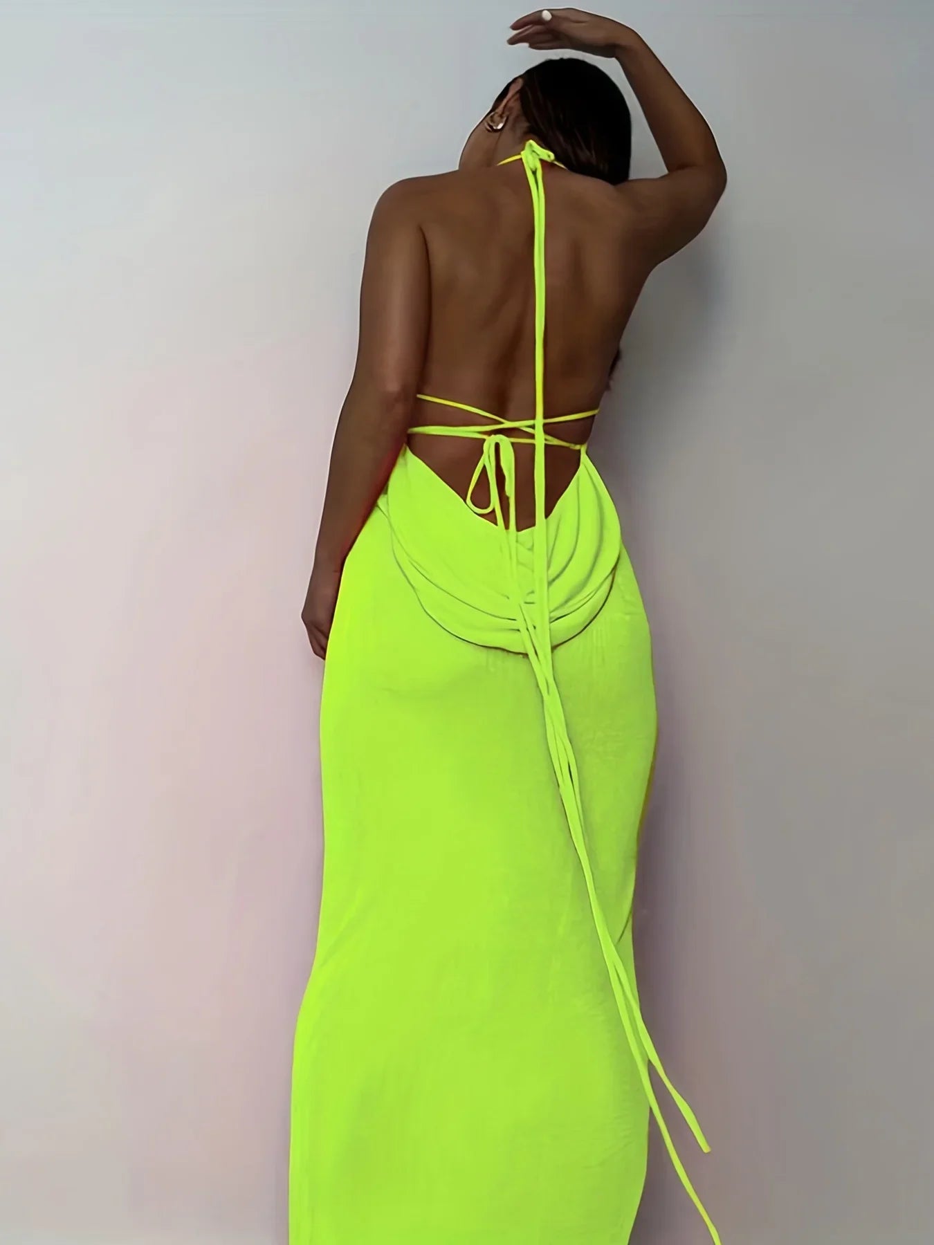 Back view of an elegant womens strapless evening gown in bright neon green with a tied design