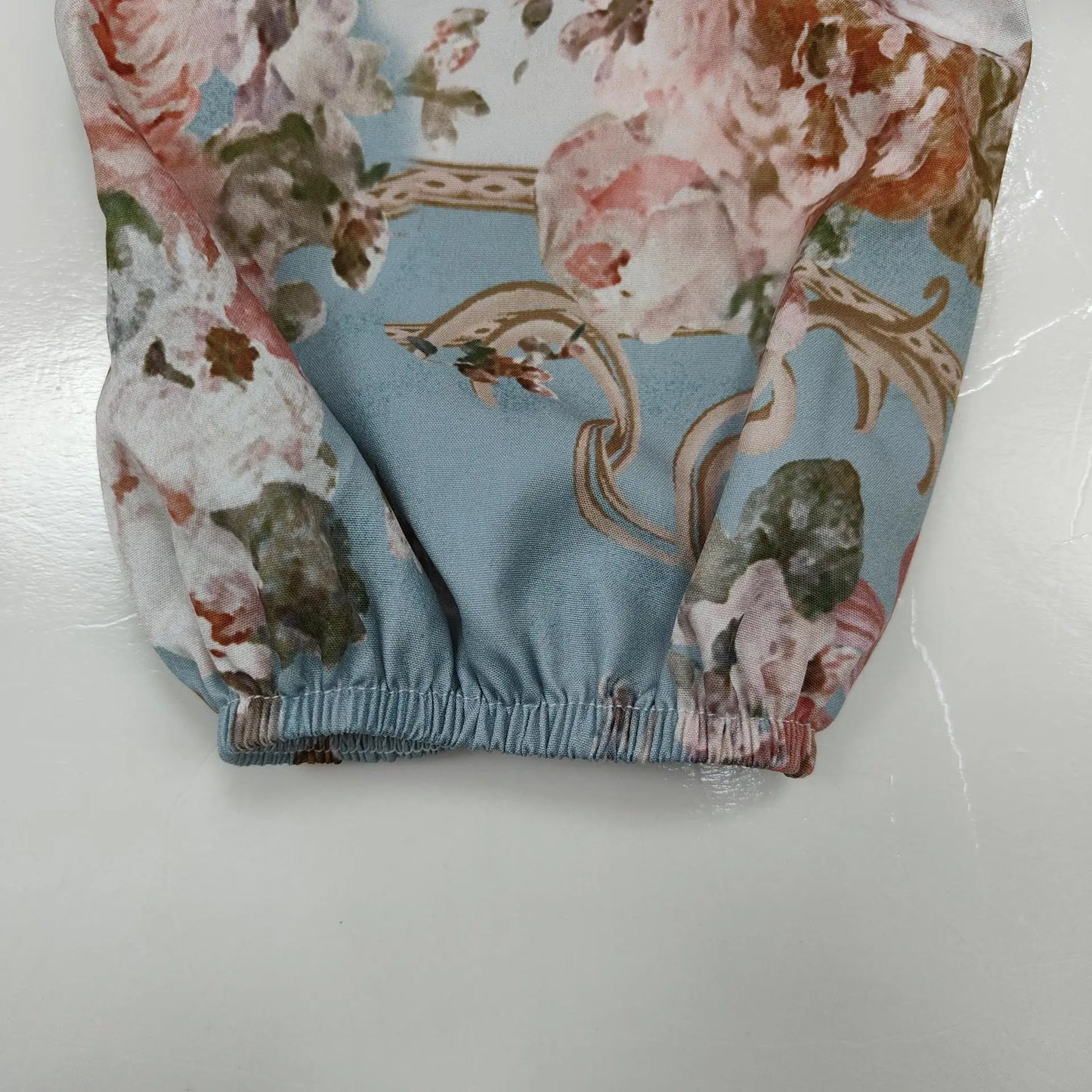 Close up of elastic cuff on pastel blue floral vintage autumn dress for women showing gathered sleeve detail