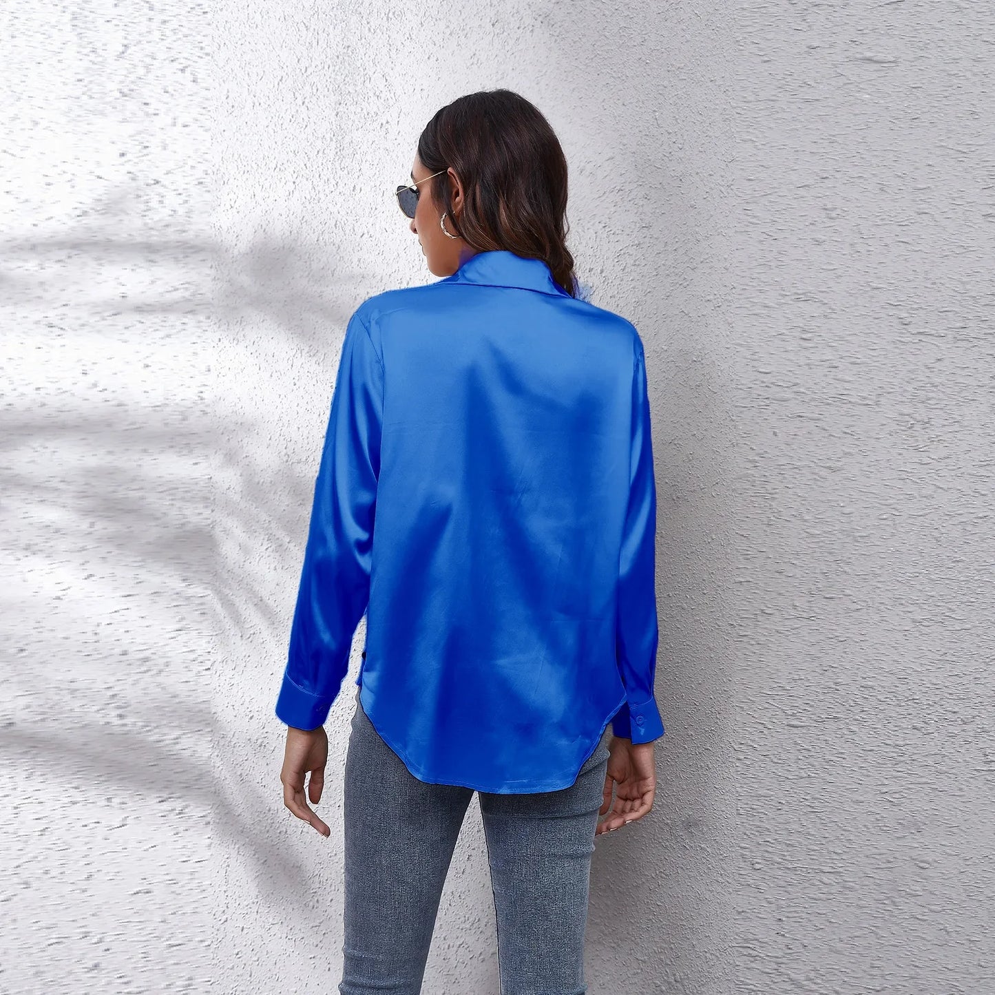 Back view of a stylish blue fashion satin blouse ladies paired with casual denim for a chic look