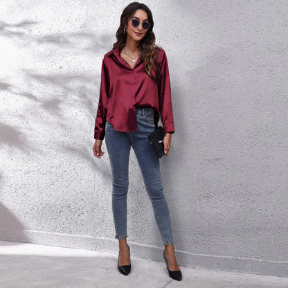 Stylish fashion satin blouse ladies in burgundy paired with skinny jeans and heels