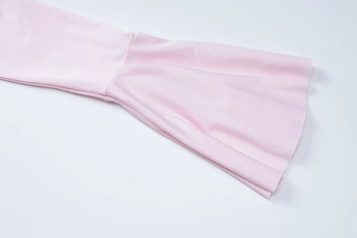 Detail of the flared sleeved v neck ruffle dress in soft pink fabric highlighting the elegant sleeve design