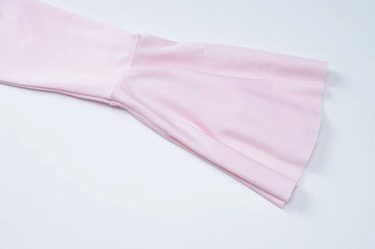 Detail of the flared sleeved v neck ruffle dress in soft pink fabric highlighting the elegant sleeve design