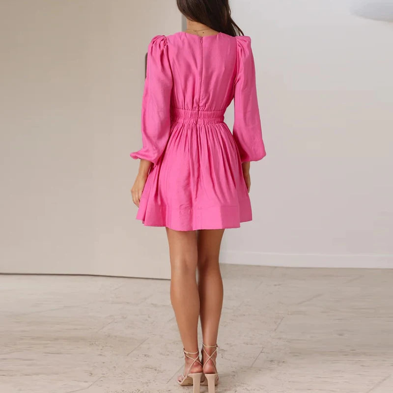 Model wearing EtherealBe elegant v neck long sleeve mini dress in pink with smocked waist and puff sleeves
