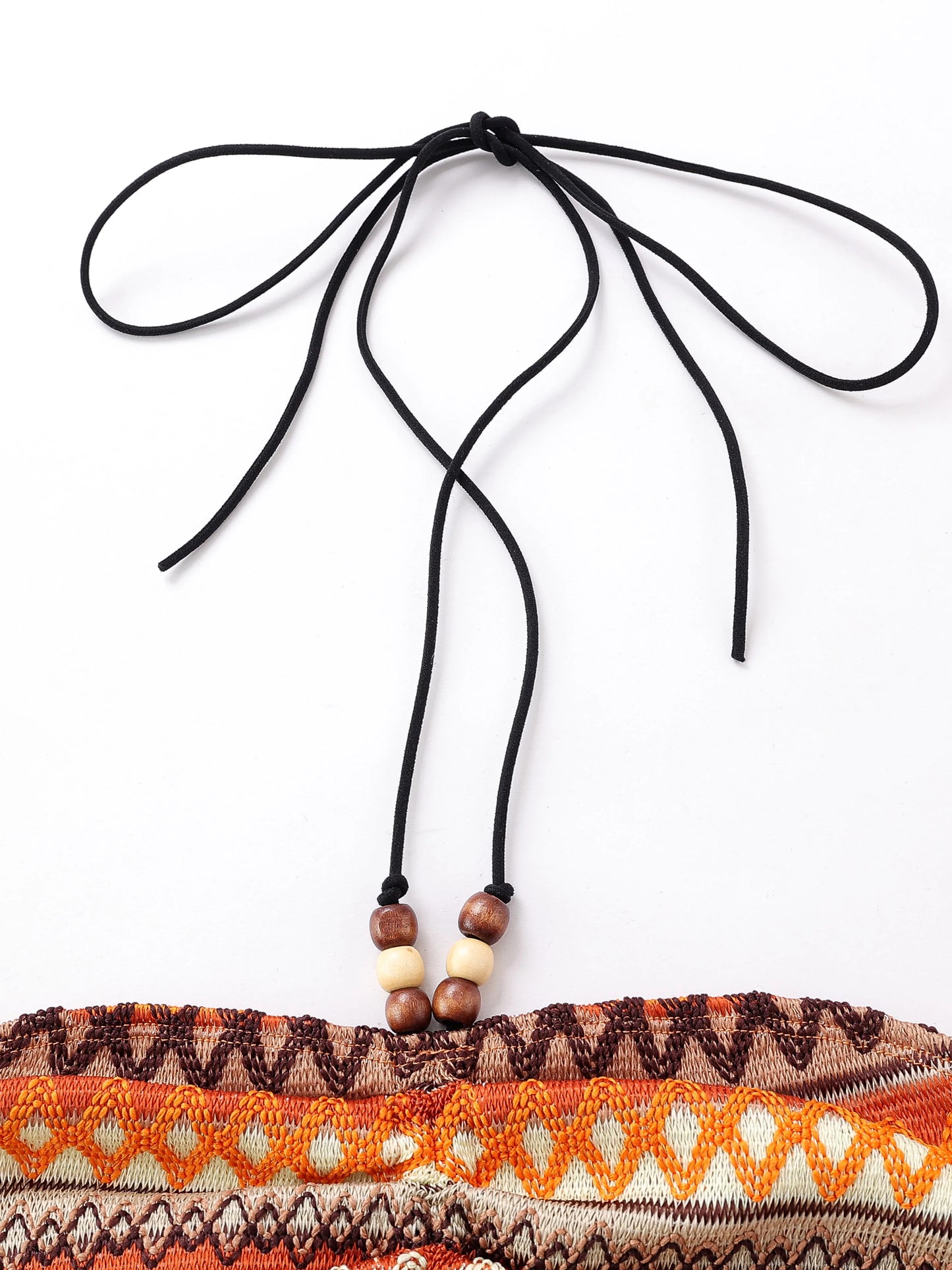 Close-up of geo pattern beaded halter crop top featuring adjustable ties and wooden beads