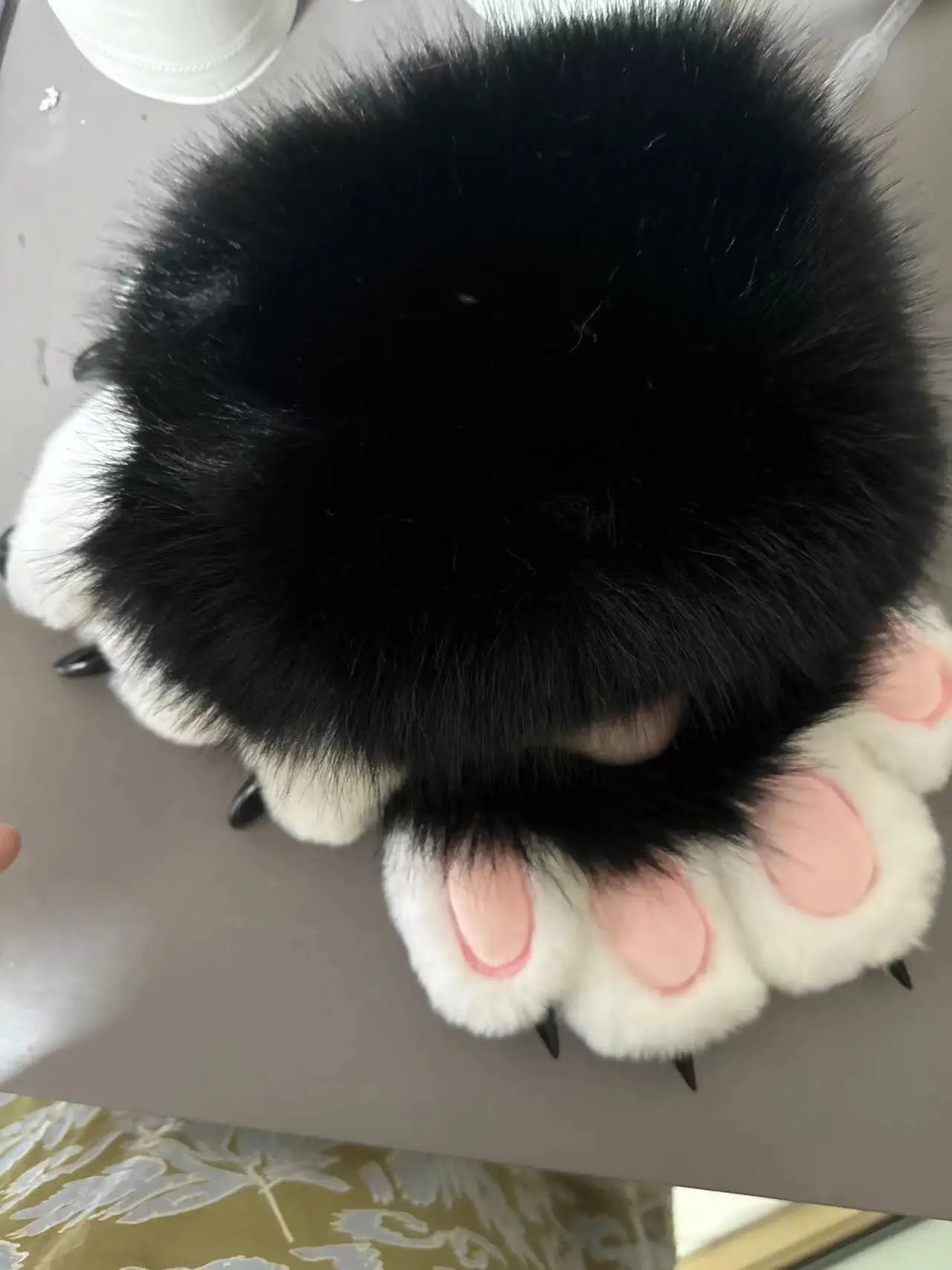 Top view of Halloween faux fur cat claw mittens with black fur and pink paw details