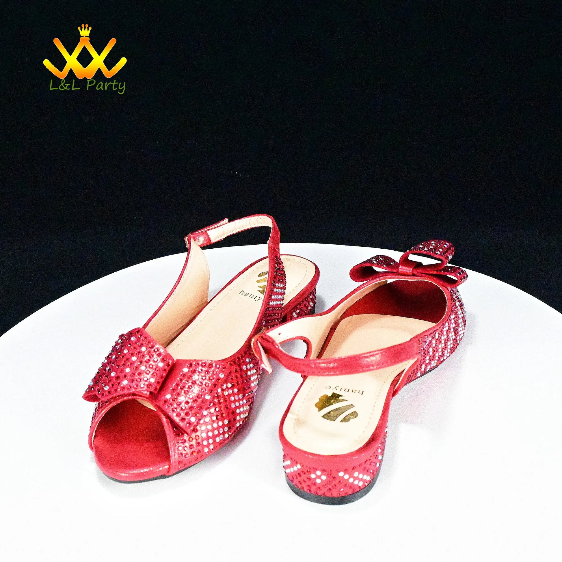 Red sequined peep toe slingback flats with bow detail on white pedestal by EtherealBe Fashionable shoes and bag set.