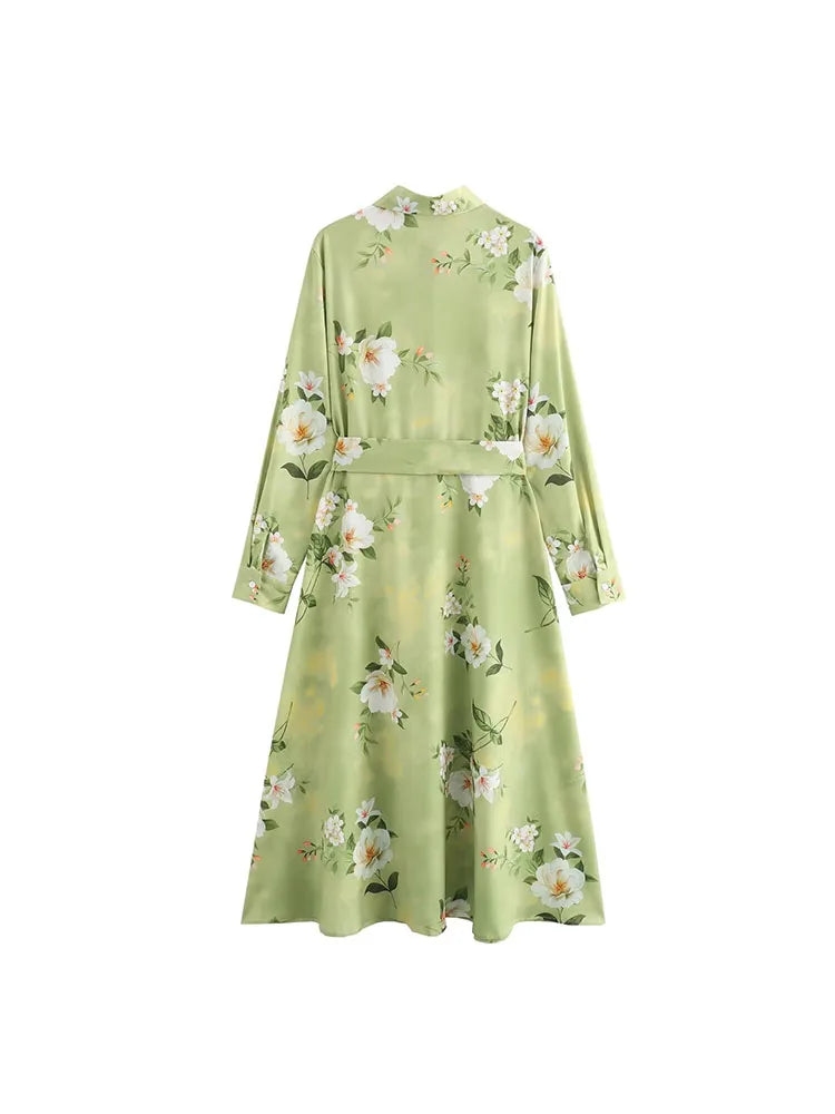 Back view of a long sleeve spring floral midi dress in soft green with elegant floral patterns