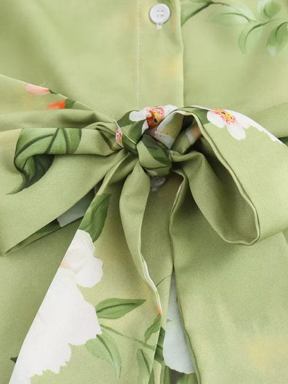 Detail of long sleeve spring floral midi dress highlighting tied bow and floral pattern