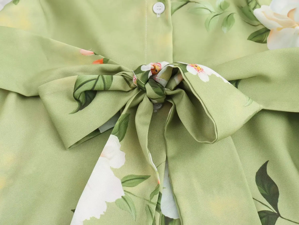 Close-up of long sleeve spring floral midi dress featuring a vibrant floral print and tie detail