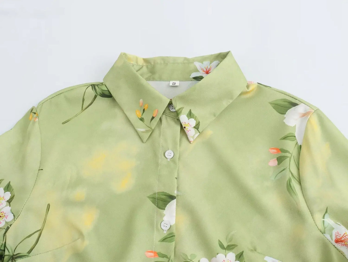 Close-up of an EtherealBe long sleeve spring floral midi dress with a green background and white floral patterns
