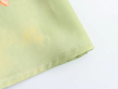 Detail of the hem on an EtherealBe long sleeve spring floral midi dress in soft green fabric