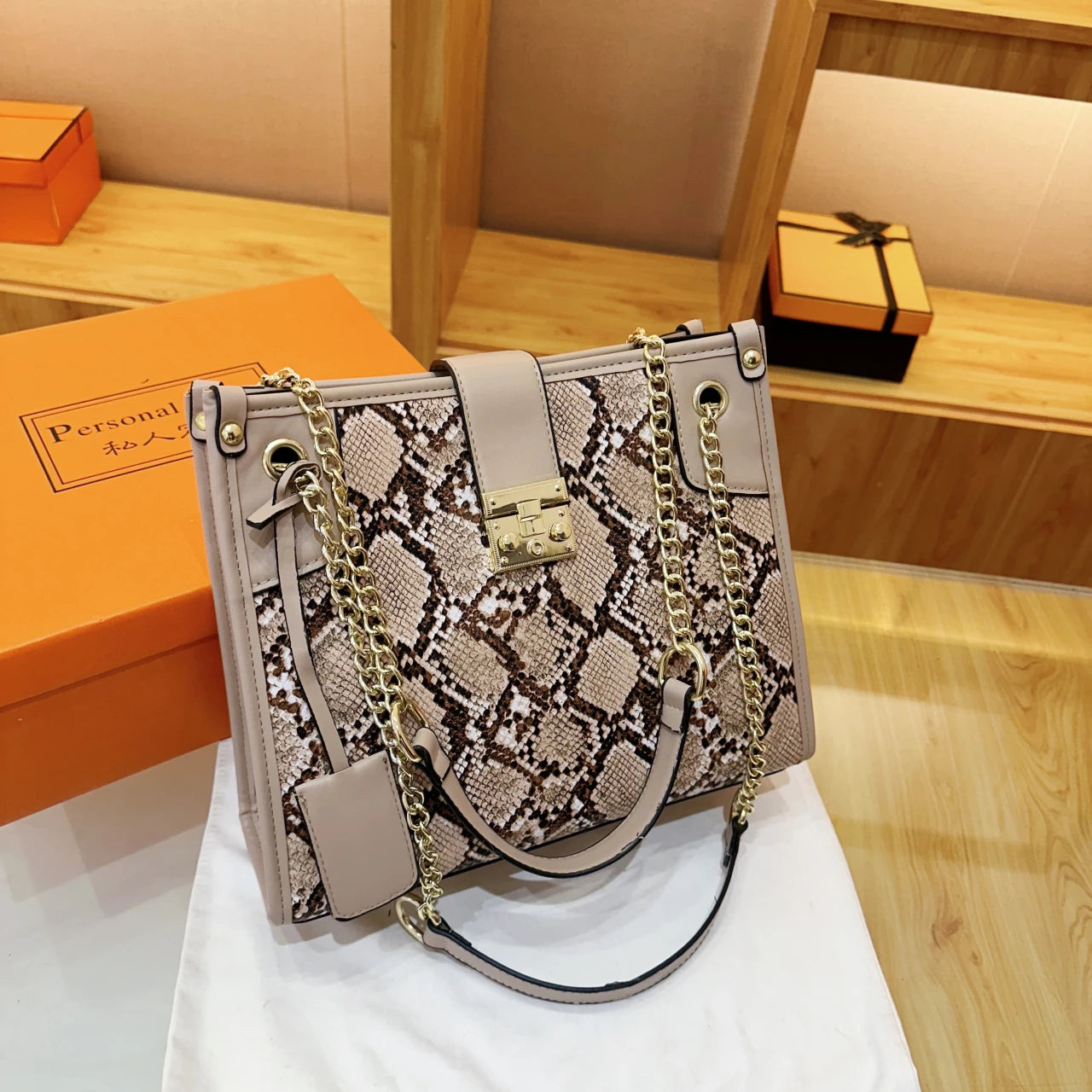 EtherealBe snake print leather shoulder bag with gold chain accents and stylish design