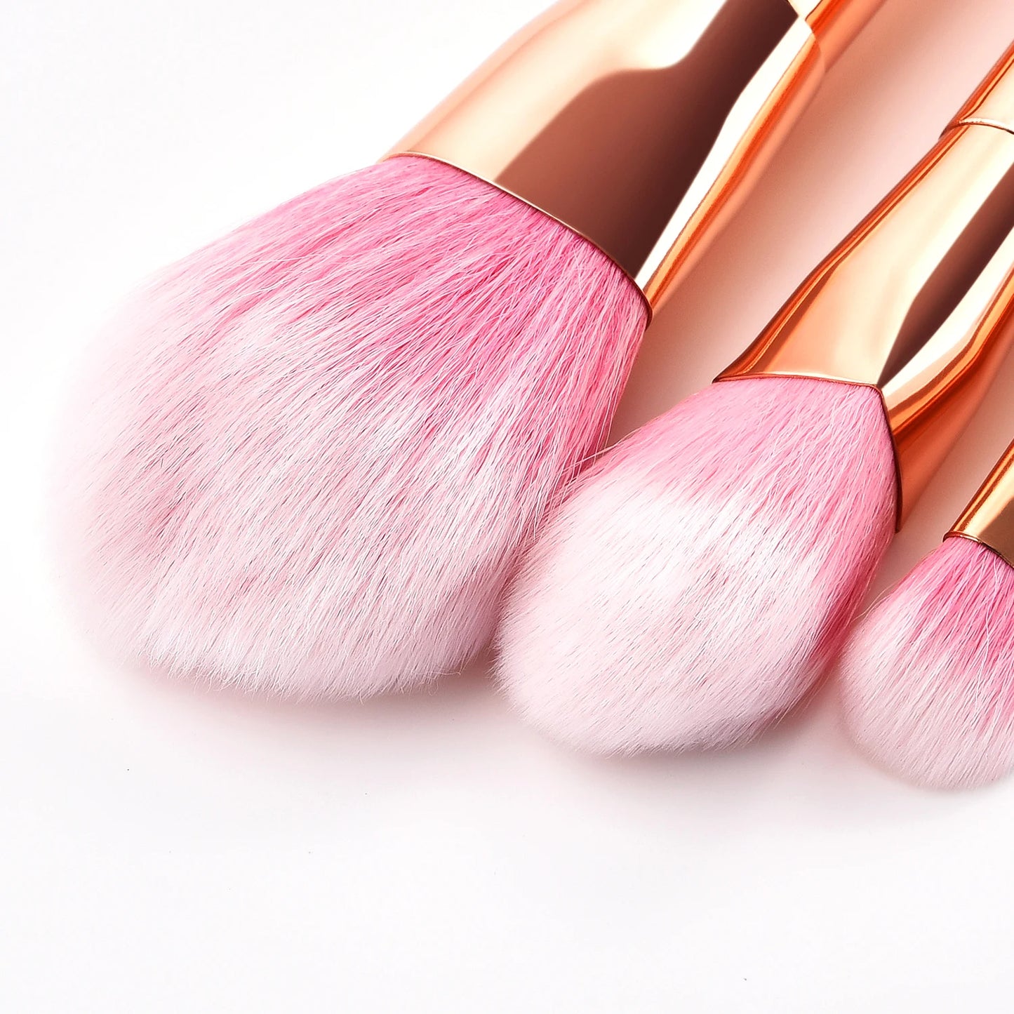 Three pink professional makeup brush tools for women with soft bristles and elegant rose gold handles