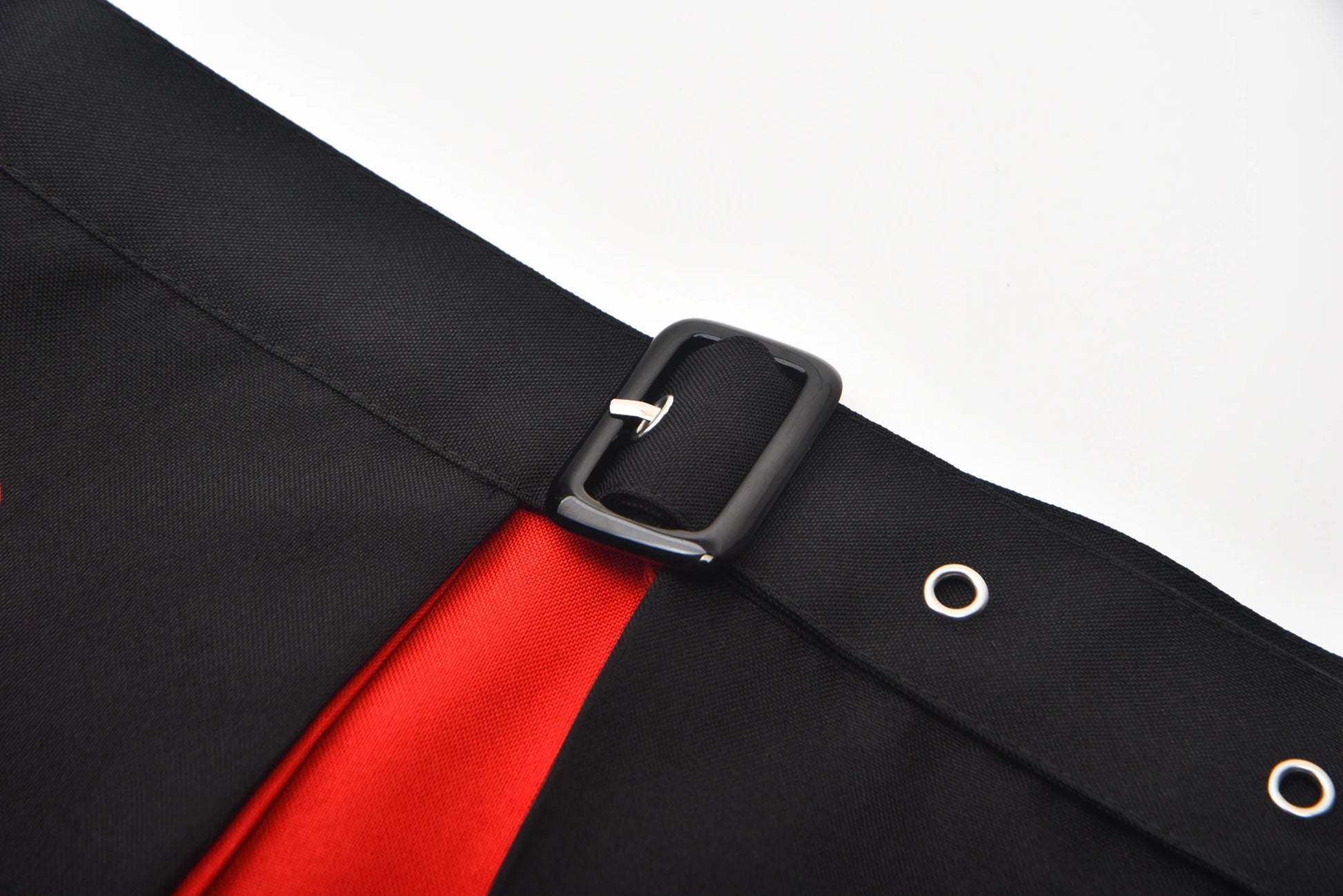 Detail view of the Queen of Hearts costume for women featuring a black and red design with buckle accents