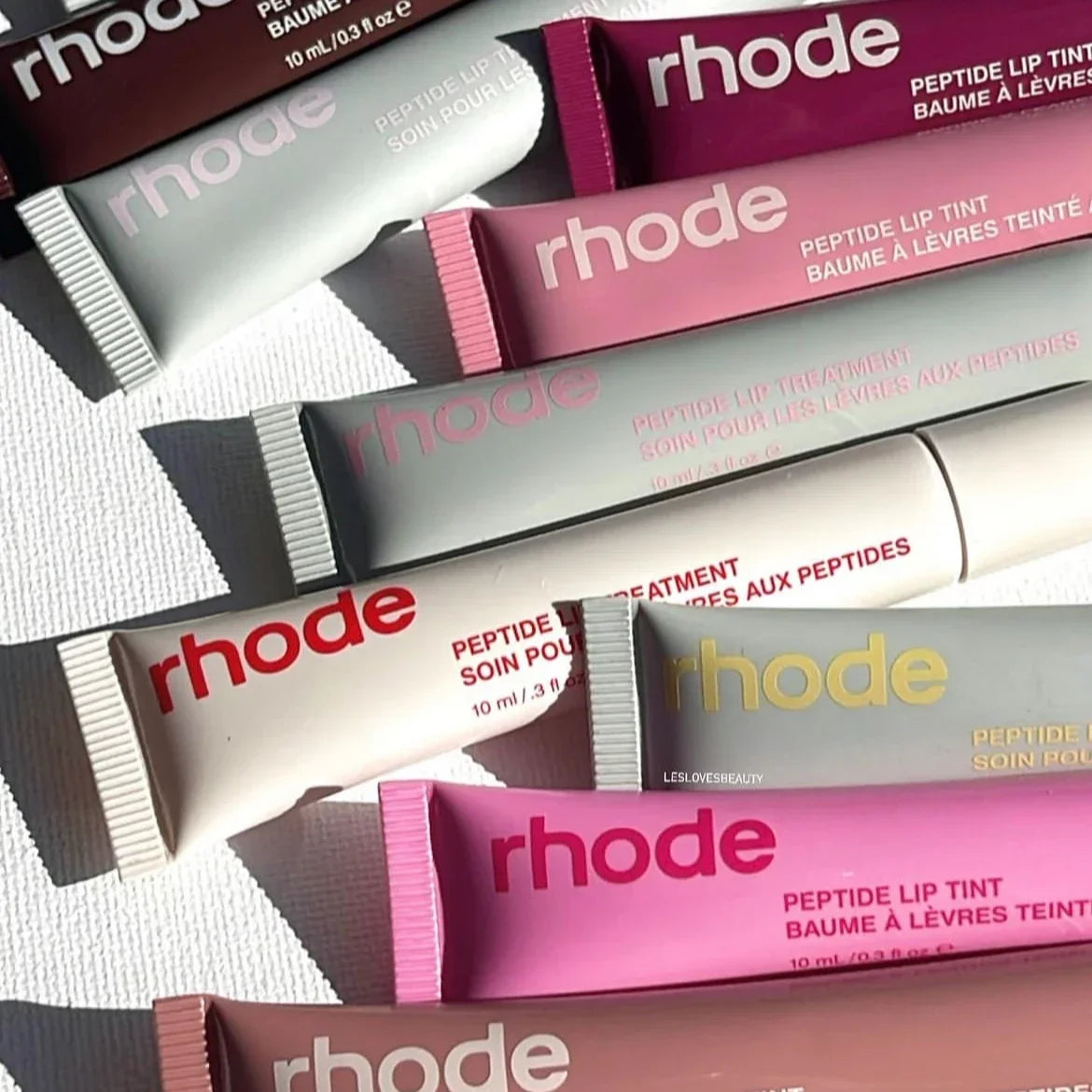 Assorted Rhode lip tubes in pink and neutral shades Flavored moisturizing lip balm for dry lips in squeeze tubes