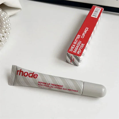 Rhode peptide lip treatment tube and red box on white surface Flavored moisturizing lip balm for dry lips.