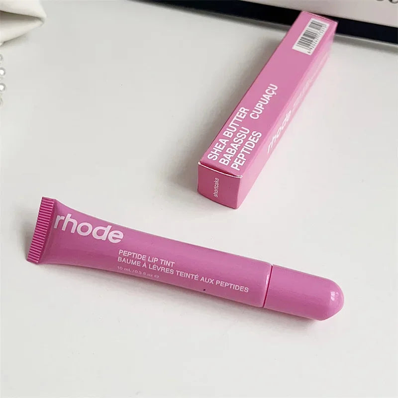 Pink peptide lip tint tube and box on white surface, Flavored moisturizing lip balm for dry lips.