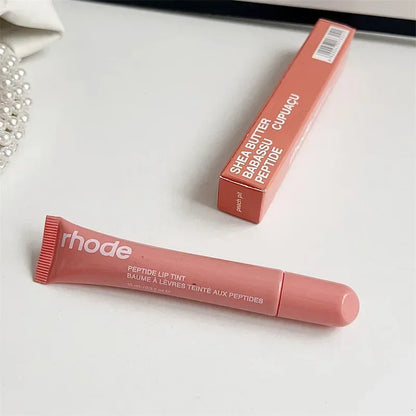 Rhode pink peptide lip tint tube and matching box on white surface Flavored moisturizing lip balm for dry lips