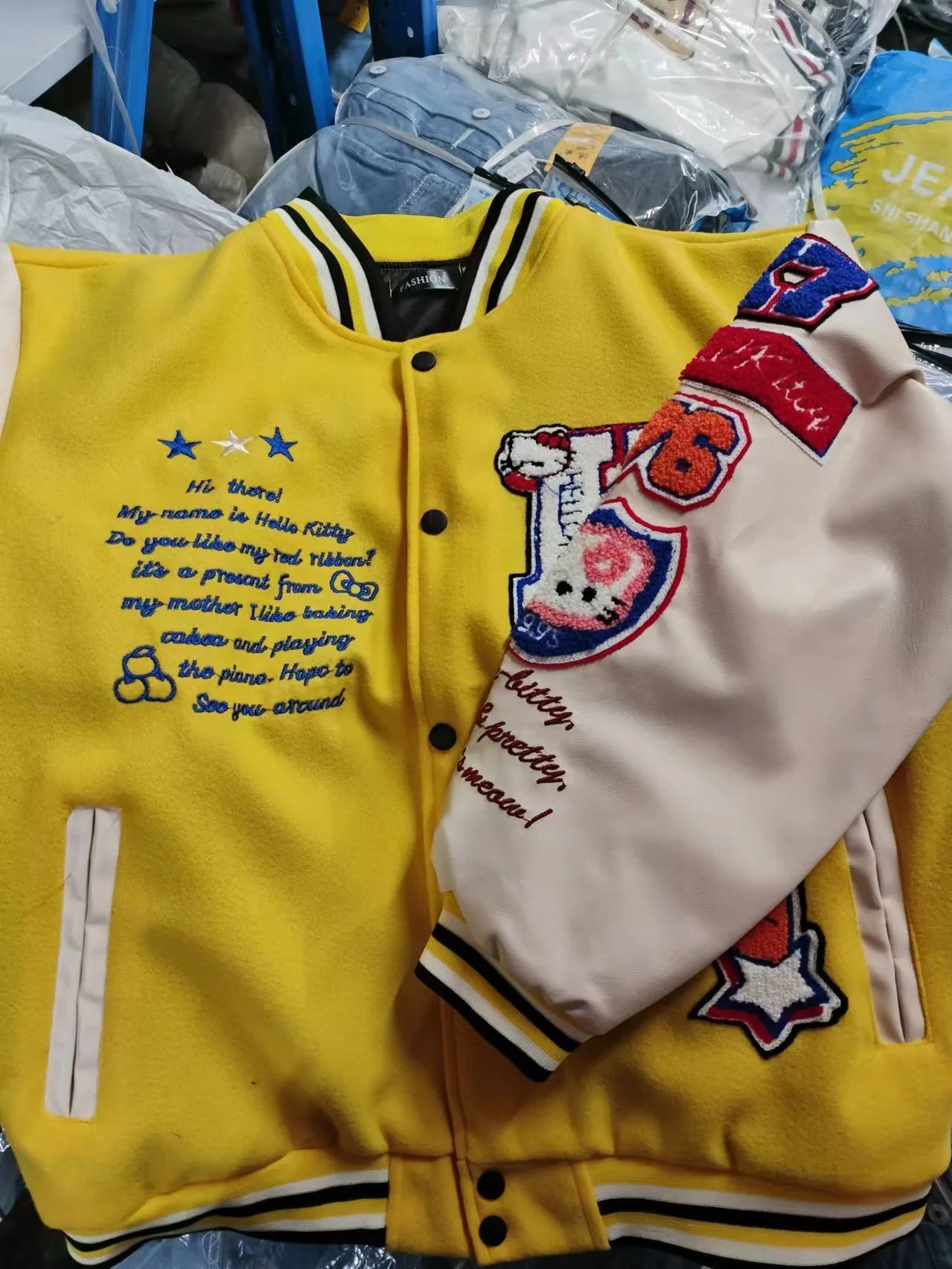 Yellow Hello Kitty baseball jacket with cream sleeves embroidered patches and striped collar