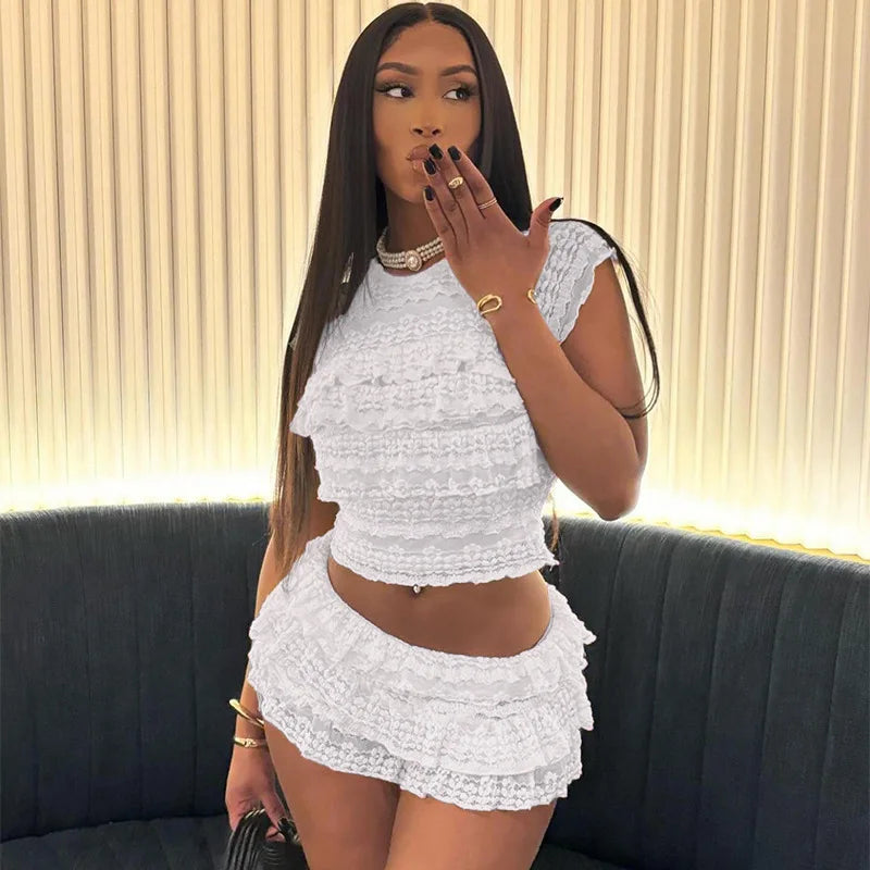 Model wearing a stylish see through tassel skirt set in white with a matching crop top