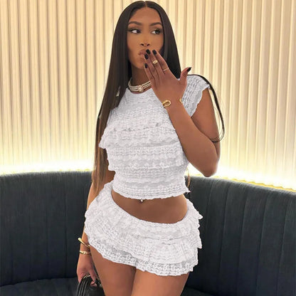 Model wearing a stylish see through tassel skirt set in white with a matching crop top