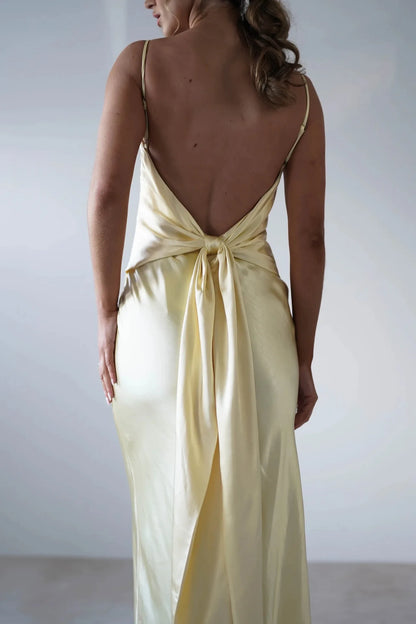 EtherealBe sexy satin halter dress in soft yellow with an elegant low back design