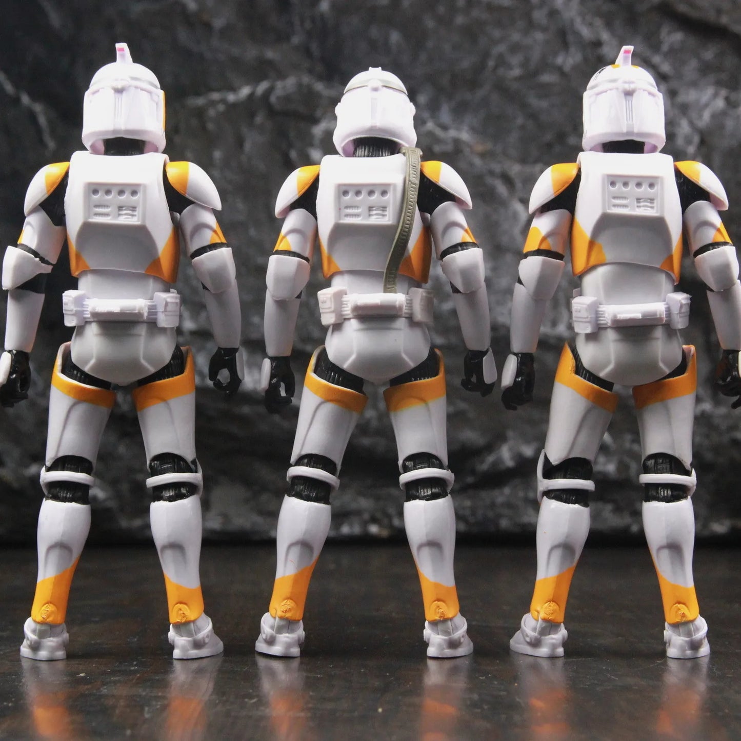 Three EtherealBe Star Wars 212th Clone Trooper action figures in white and orange armor from the back