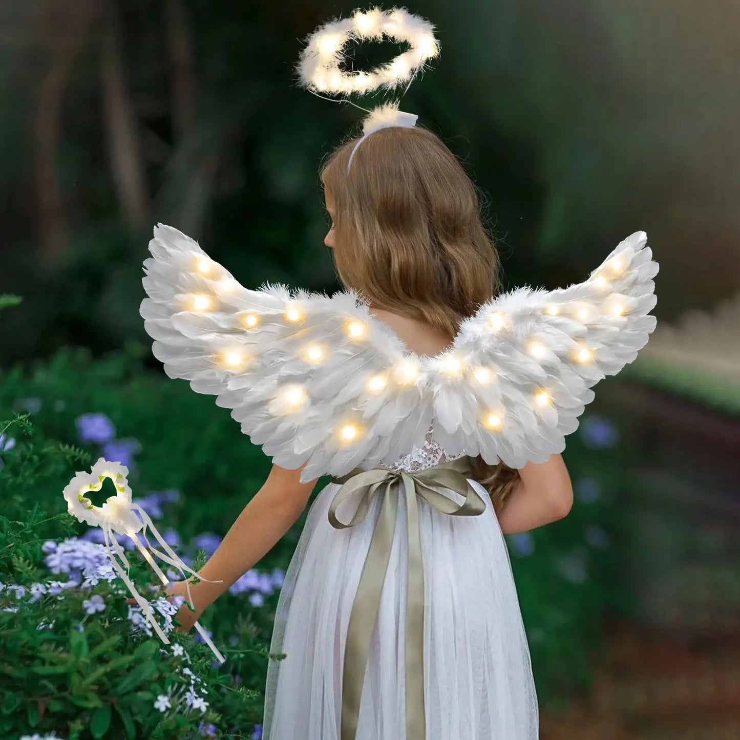 White lighted wings and halo with wand on woman in flowing dress in garden adult fairy wand and halo costume set