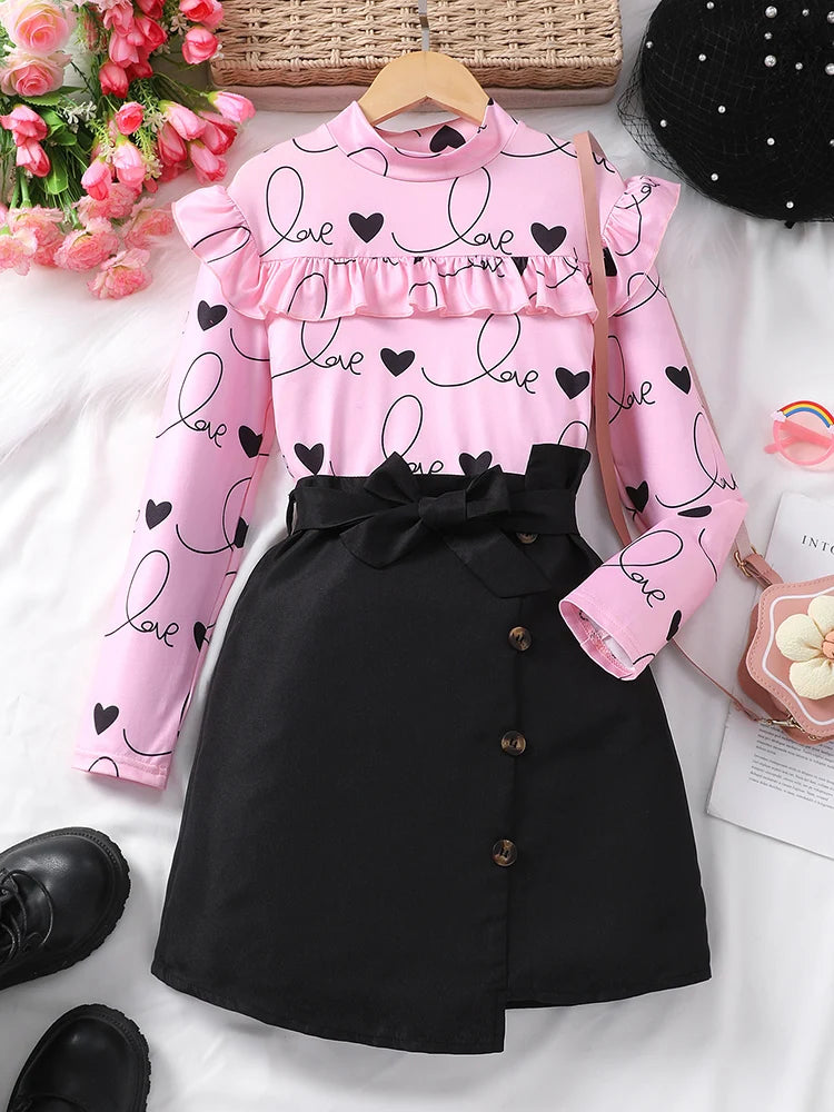 EtherealBe sweet ruffle long sleeve top and skirt set featuring a heart print and bow detail