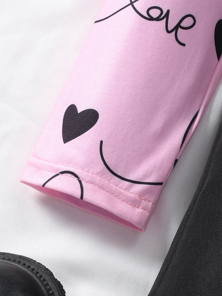 Close-up of the sleeve detail of a sweet ruffle long sleeve top and skirt in pink with heart prints