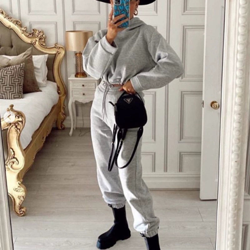 Trendy women's hoodie and joggers set in gray with stylish black accessories and a chic hat