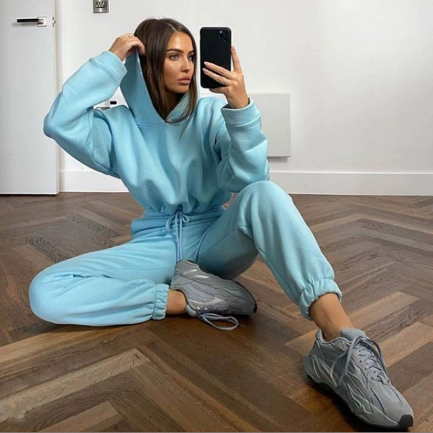 Stylish woman in a light blue trendy women's hoodie and joggers set with a relaxed fit