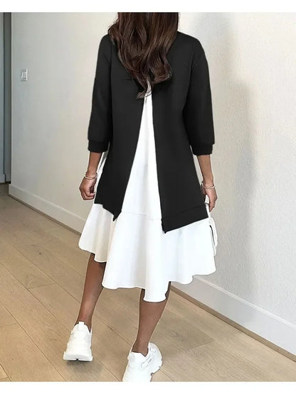 Model wearing fashionable patchwork midi dress with black split overlay and white tiered ruffle skirt paired with sneakers
