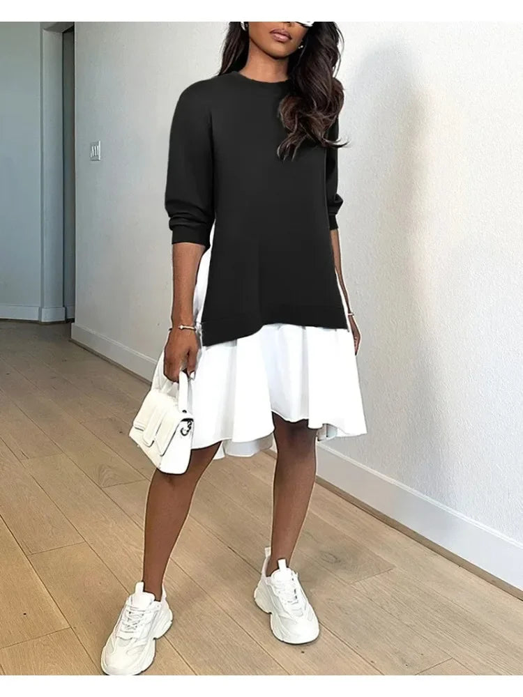Woman wearing EtherealBe fashionable patchwork midi dress layered under a black sweater with white sneakers and handbag