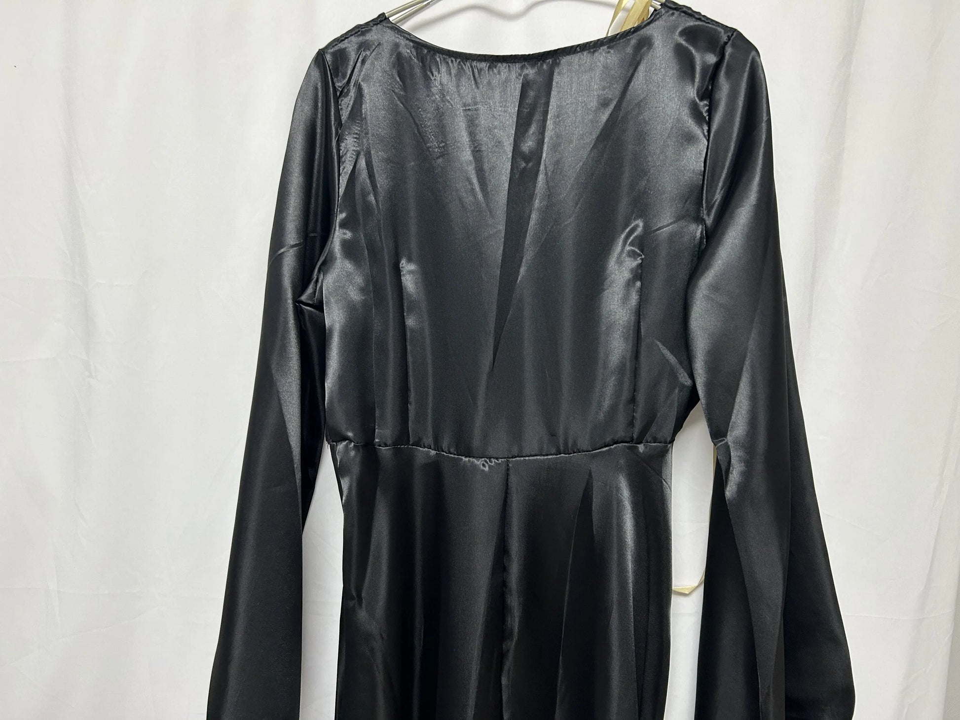 Back view of a sleek black vampire bride cosplay costume with long sleeves and satin finish