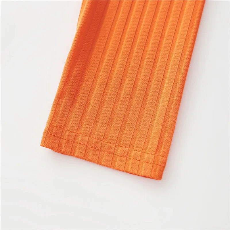 Close-up of orange ribbed fabric for the Velma costume for women, featuring detailed stitching