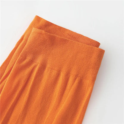 Close-up of bright orange leggings for women, perfect for a Velma costume for women