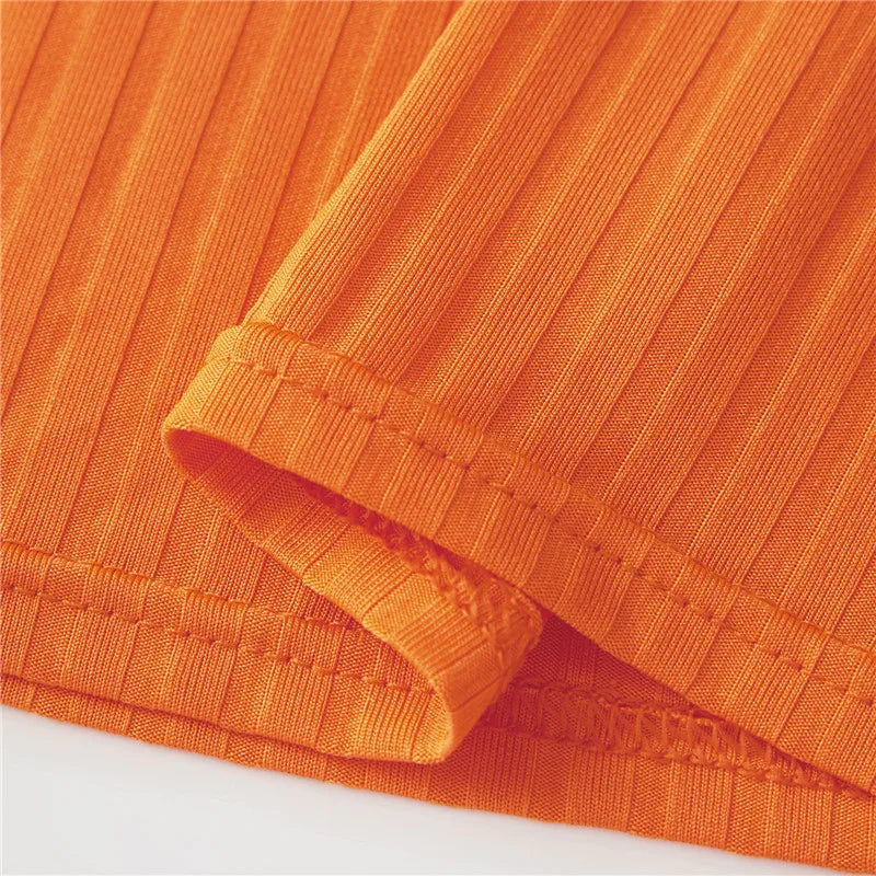 Close-up of the textured fabric of the Velma costume for women in vibrant orange