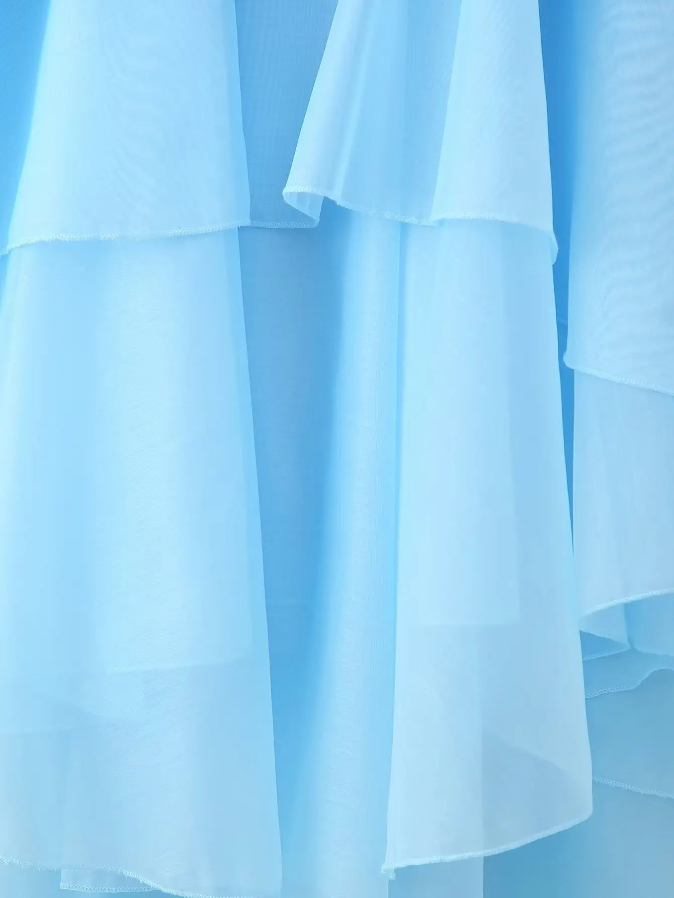 Elegant layered decorative dress in soft blue featuring flowing sheer fabric layers