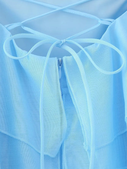 Back view of an elegant layered decorative dress showcasing delicate straps and a light blue color