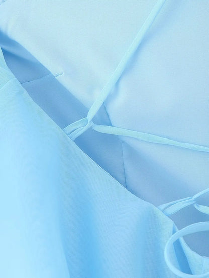 Close-up of an elegant layered decorative dress in soft blue fabric with delicate ties