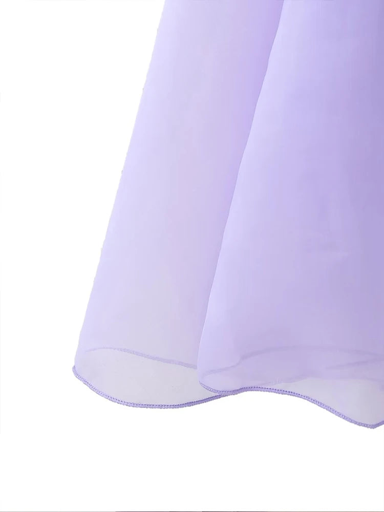 Close-up of the elegant layered decorative dress in soft purple fabric flowing gracefully