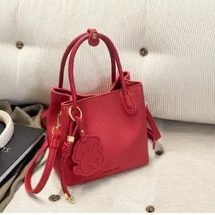 Stylish red handbag with a cute charm, perfect as fashionable work bags for women