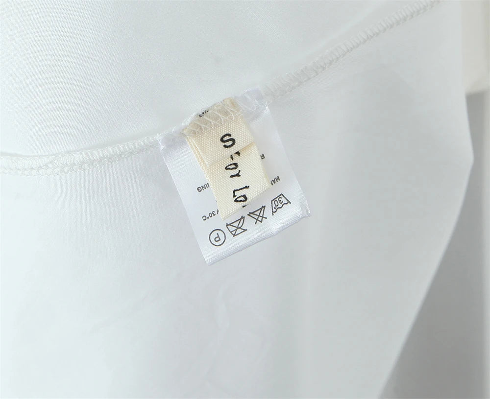 White lace panel midi dress for women with care label showing size and washing instructions