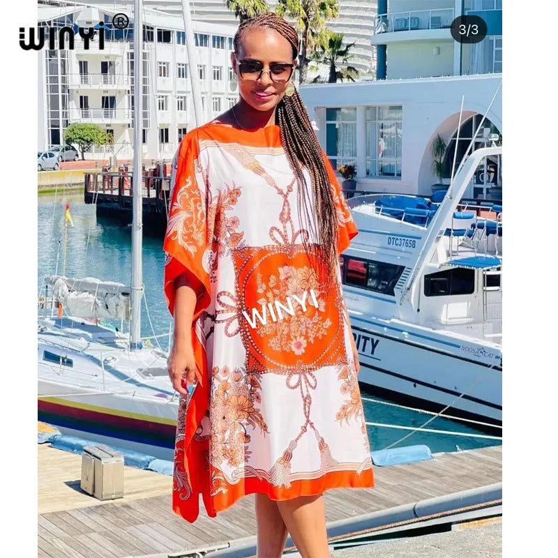 EtherealBe long femme chic vestido for women with vibrant orange and floral patterns in a sunny outdoor setting
